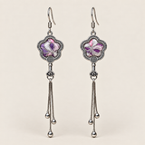 Lilac Serenade floral tassel earrings, front view showing lilac and pink petals with pale curved lines in flower-shaped metal frames with three chain tassels with rounded drops.