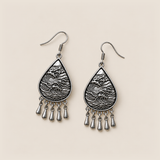 Midnight Currents earrings lying flat with wave-relief metal backs and five short drops visible.