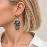 Close-up of a Silver Tide earring worn with the wave-relief metal reverse facing outward.