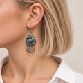 Close-up of a Silver Tide earring worn with the wave-relief metal reverse facing outward.