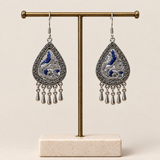 Silver Tide earrings hanging from a display stand with their embroidered fronts facing forward.