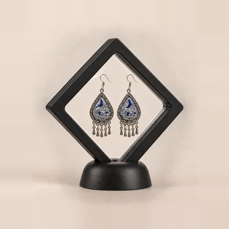 Silver Tide earrings shown inside a black display frame; sales packaging is not confirmed.