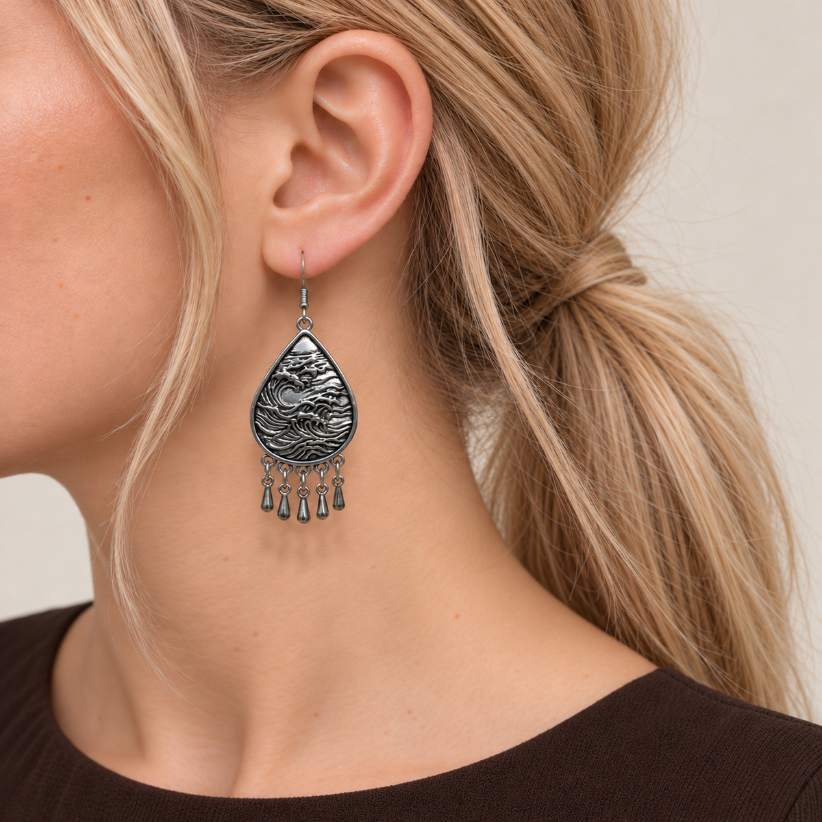 Close-up of a Verdant Reverie earring worn with the sculpted wave-relief metal reverse facing outward.
