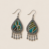 Verdant Reverie earrings laid flat, showing different cream embroidered curves across teal, olive-green and brown textile fronts.
