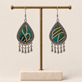Verdant Reverie embroidered teardrop earrings hanging from a T-bar stand, with five short drops on each earring.