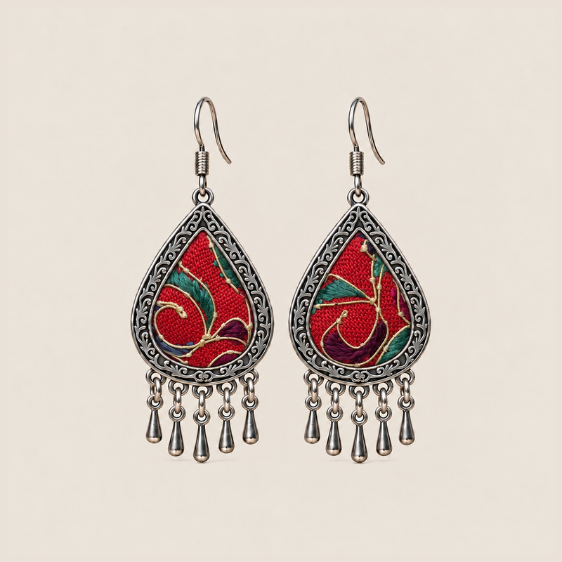 Crimson Aurora teardrop earrings with red horsehair embroidery, green and purple accents, pale curved lines and five short drops.