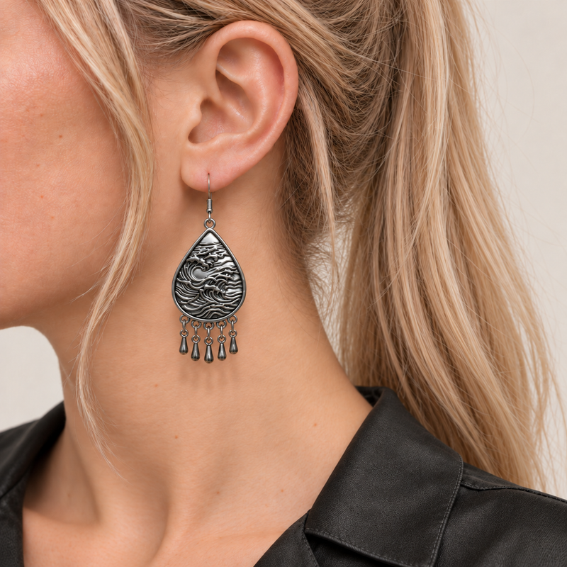 Close-up of a Crimson Aurora earring worn with its wave-relief metal reverse and five short drops facing outward.
