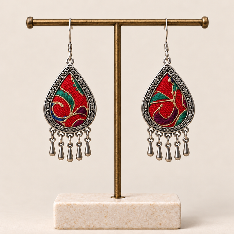 Crimson Aurora embroidered teardrop earrings hanging from a T-bar stand, with five short drops on each earring.