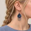 Close-up of a Violet Reverie earring worn with blue, dark purple, black and pale green embroidery facing outward.
