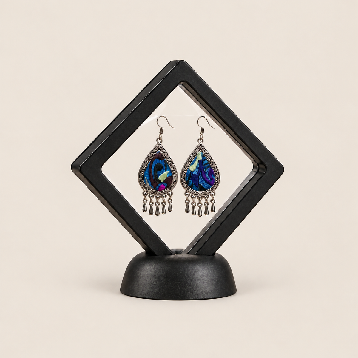 Violet Reverie earrings displayed inside a transparent, diamond-oriented black frame on a black base.