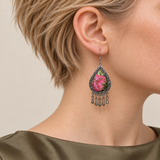 Close-up of a Petal Serenade earring worn with pink petals, green leaves and fine gold-colored outlines facing outward.