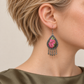Close-up of a Petal Serenade earring worn with pink petals, green leaves and fine gold-colored outlines facing outward.