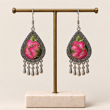 Petal Serenade floral teardrop earrings hanging from a T-bar stand, with pink petals, green leaves and five short drops each.