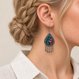 Close-up of a Twilight Mosaic earring worn with teal, pink and pale geometric stitches on black textile facing outward.