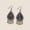 Twilight Mosaic earrings laid flat, showing different teal, pink and pale geometric embroidery patterns on black textile.