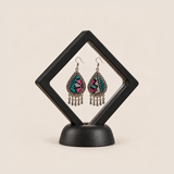 Twilight Mosaic earrings displayed inside a transparent, diamond-oriented black frame on a black base.