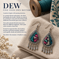DEW counted-thread embroidery story panel titled Find your own rhythm, with Twilight Mosaic earrings on folded cloth beside a teal thread spool and patterned textile.