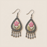 Front view of Blush Reverie earrings lying flat, showing pink flowers and differing leaf-color placement across the pair.