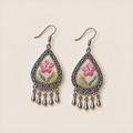 Front view of Blush Reverie earrings lying flat, showing pink flowers and differing leaf-color placement across the pair.