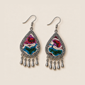 Prismatic Reverie earrings lying face up, showing different arrangements of colorful knots and ivory curves across the pair.
