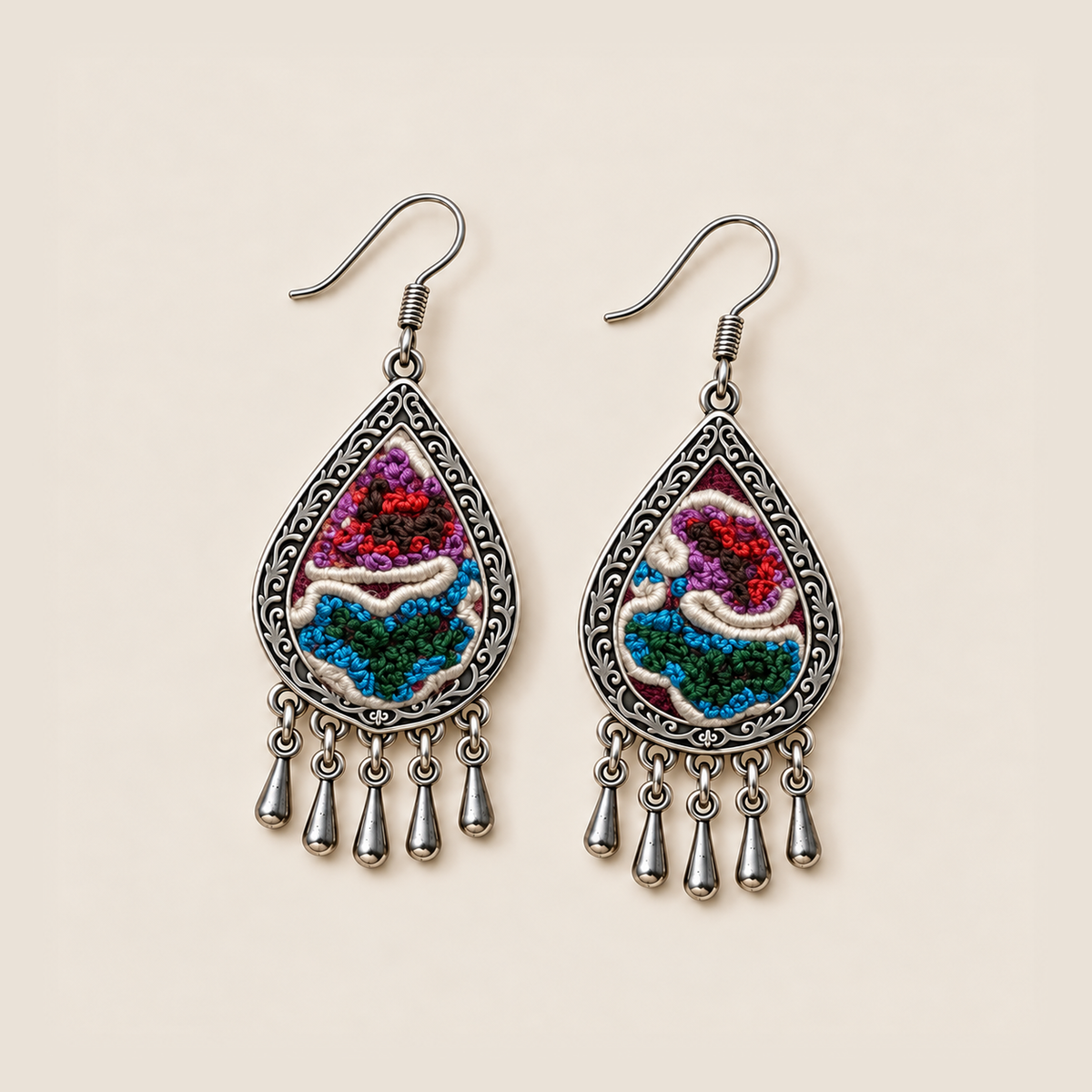 Prismatic Reverie earrings lying face up, showing different arrangements of colorful knots and ivory curves across the pair.