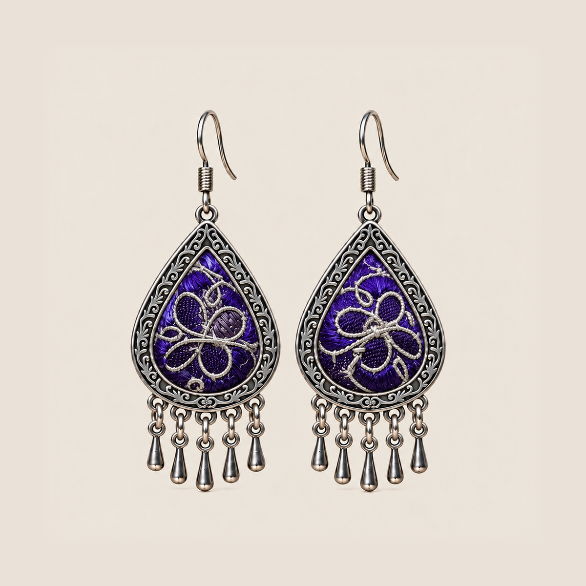 Violet Arabesque teardrop earrings with silver-white Panjin embroidery curves on purple textile and five short drops.