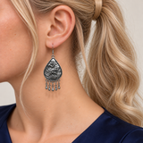 Close-up of a Violet Arabesque earring worn with its sculpted wave-relief reverse facing outward.
