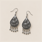 Violet Arabesque earrings lying flat with wave-relief metal backs and five short drops visible.