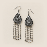 Burgundy Nocturne earrings lying flat with wave-relief backs and five long chains ending in teardrop pendants on each earring.