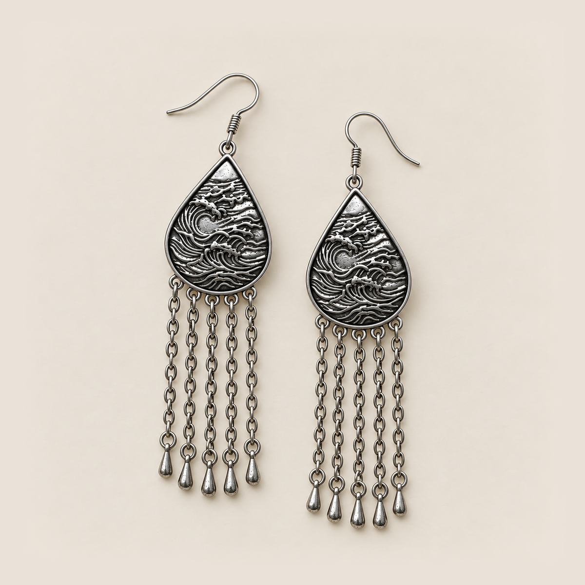 Burgundy Nocturne earrings lying flat with wave-relief backs and five long chains ending in teardrop pendants on each earring.
