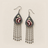Burgundy Nocturne earrings lying face up, showing differing floral embroidery sections and pale green leaves on black.