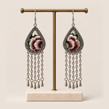 Burgundy Nocturne floral earrings hanging from a T-bar stand with five long chains and teardrop ends beneath each frame.