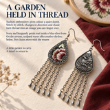A garden held in thread story panel with Burgundy Nocturne front and reverse beside burgundy cloth and an embroidery hoop.