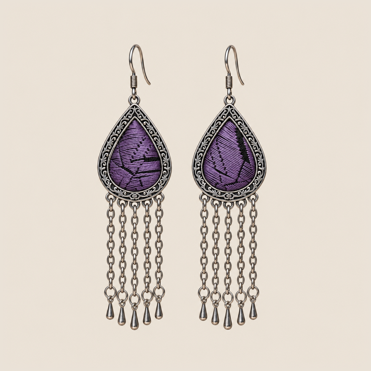 Amethyst Cadence counted-thread embroidery earrings with purple stitches, black geometric lines and five long chains with teardrop ends.