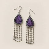 Amethyst Cadence earrings lying face up, showing different black geometric patterns among parallel purple stitches.