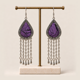 Amethyst Cadence earrings hanging from a T-bar stand with five long chains and teardrop ends beneath each embroidered frame.