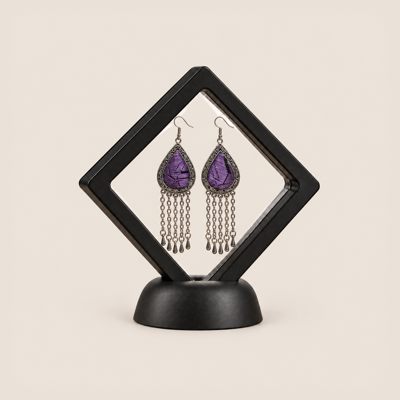 Amethyst Cadence long tassel earrings displayed inside a clear diamond-shaped frame with a black border and base.