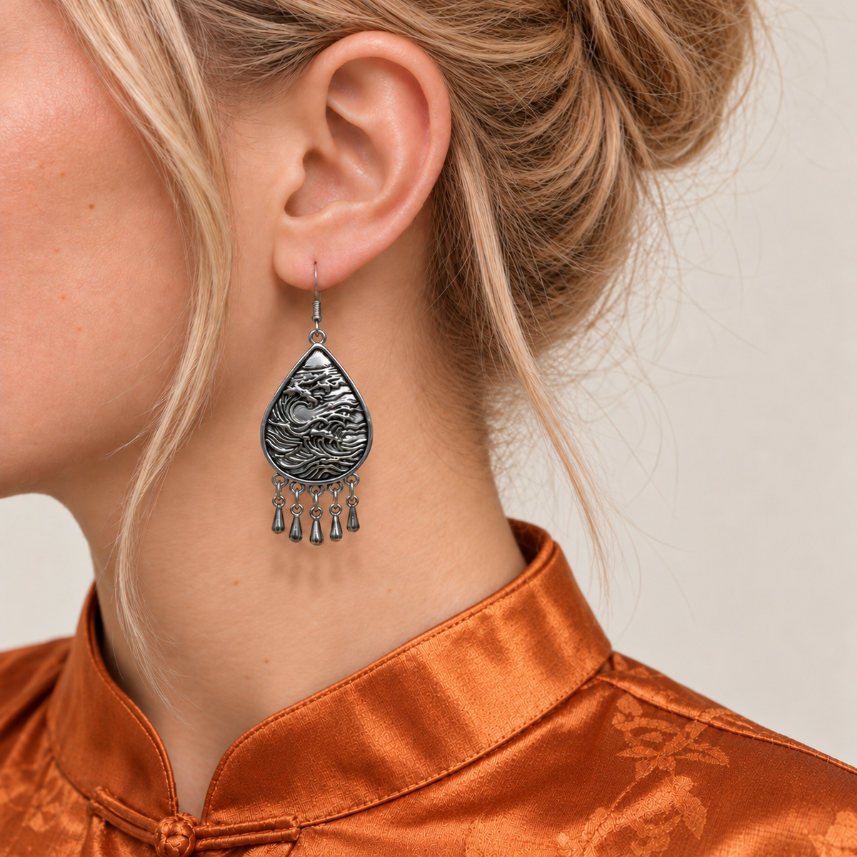 Close-up of a Fuchsia Tide earring worn with its sculpted wave-relief reverse facing outward.