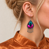 Close-up of a worn Fuchsia Tide earring showing teal and vivid pink embroidery and five short drops.