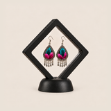 Fuchsia Tide earrings displayed inside a clear diamond-shaped frame with a black border and base.