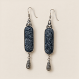 Front detail of Indigo Stillness earrings, showing different pale batik patterns, round top accents and engraved teardrops.