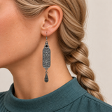 Verdant Blush earring worn with its scrollwork reverse and central oval motif facing outward, with one teardrop below.