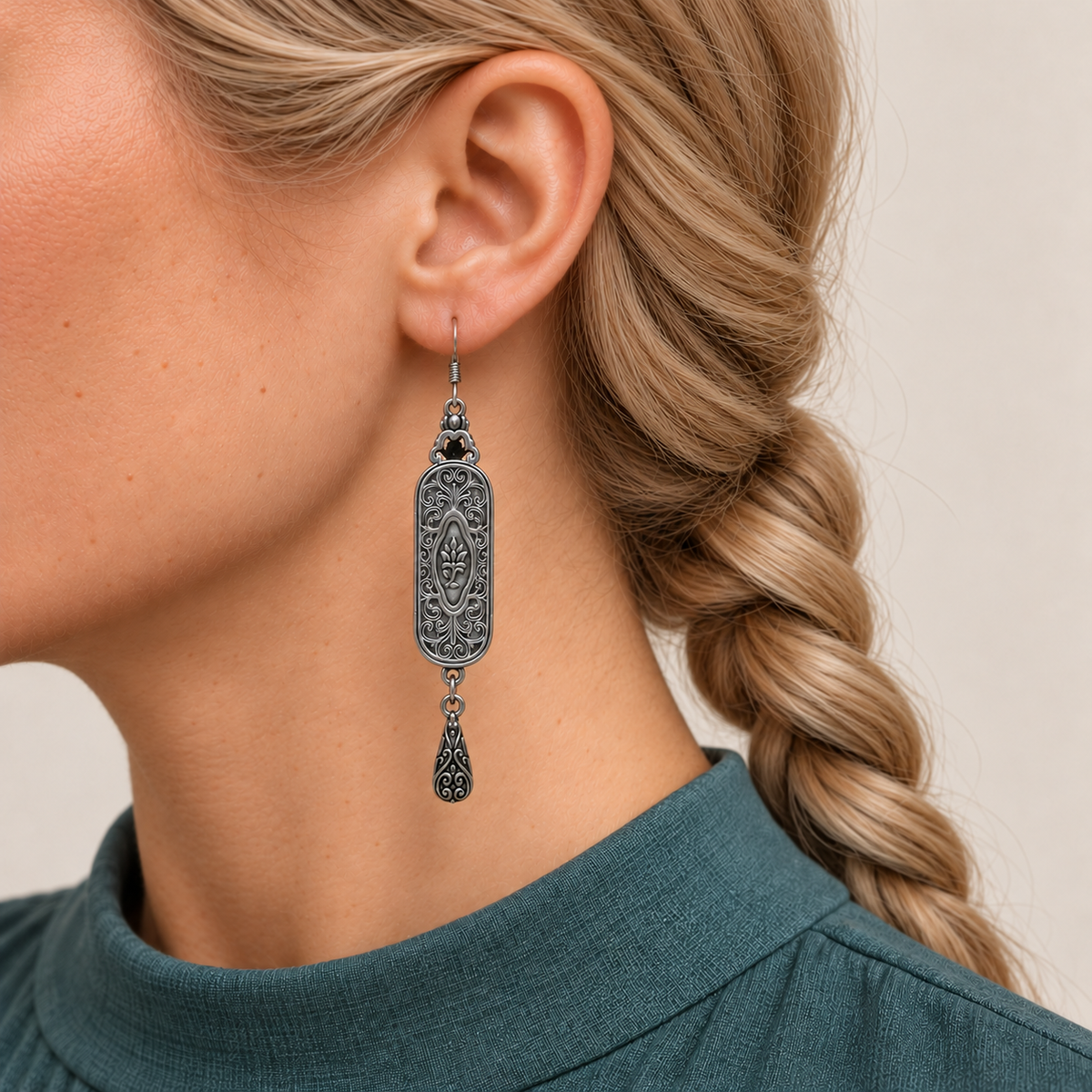 Verdant Blush earring worn with its scrollwork reverse and central oval motif facing outward, with one teardrop below.