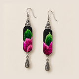 Front close-up of Verdant Blush earrings, showing different green and pink stitched sections on black textile panels.