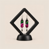 Verdant Blush embroidered earrings presented in a black diamond-shaped display frame on a matching base.