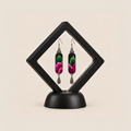 Verdant Blush embroidered earrings presented in a black diamond-shaped display frame on a matching base.