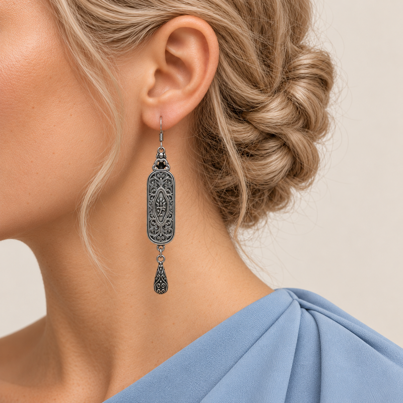 Pastel Cadence earring worn with the scrollwork reverse and central oval motif facing outward above one engraved teardrop.