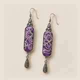 Front detail of Violet Luminance earrings showing different pale couched outlines over purple stitched panels.
