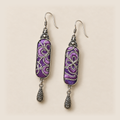 Front detail of Violet Luminance earrings showing different pale couched outlines over purple stitched panels.