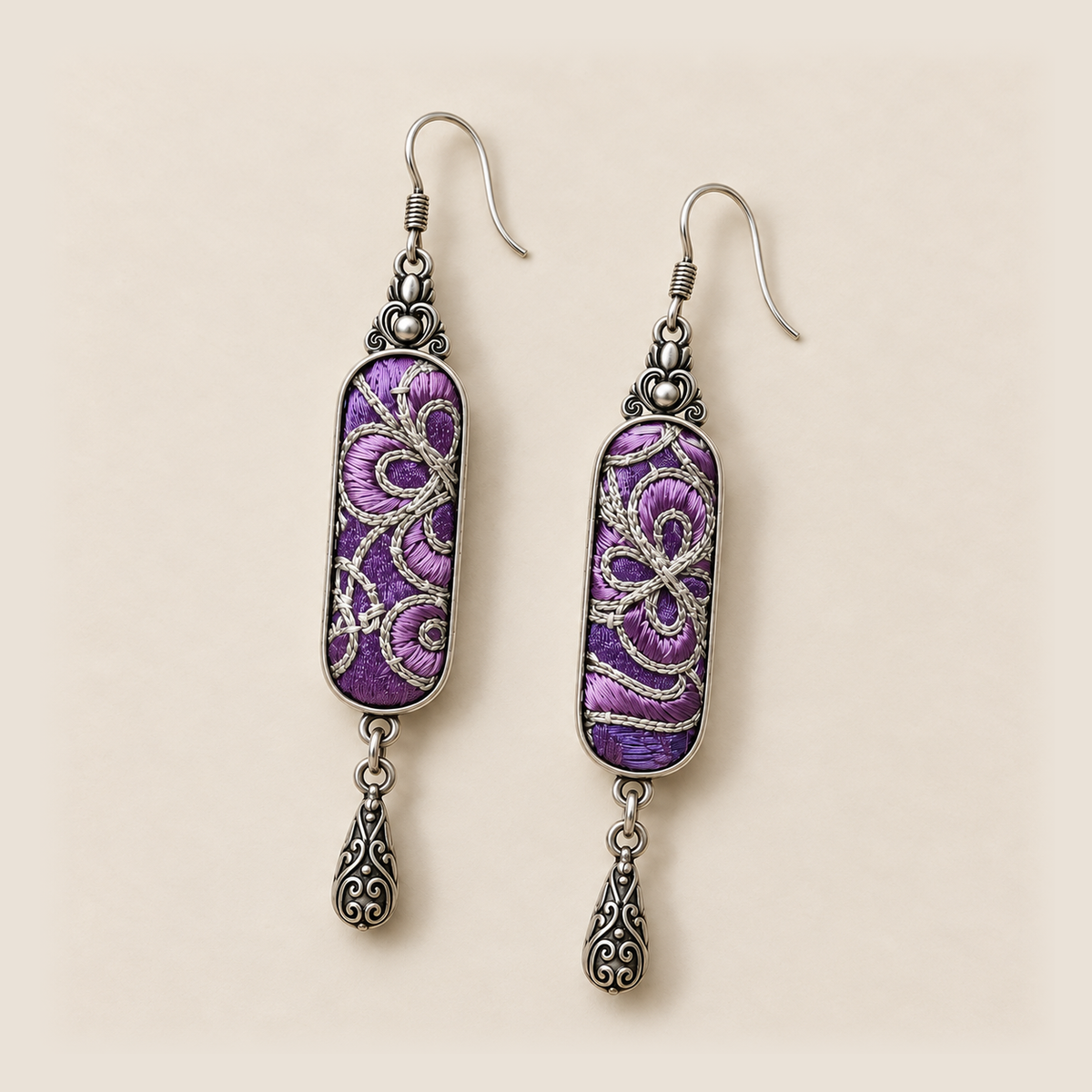 Front detail of Violet Luminance earrings showing different pale couched outlines over purple stitched panels.